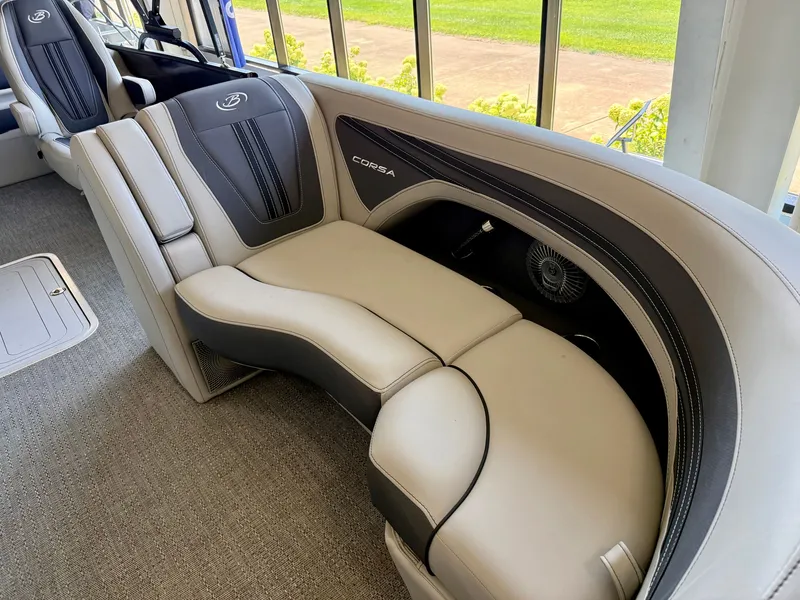 Slide: The Image of The 2025 Barletta Corsa 23UC features luxurious cream and black upholstered seating in a sleek design. - 13