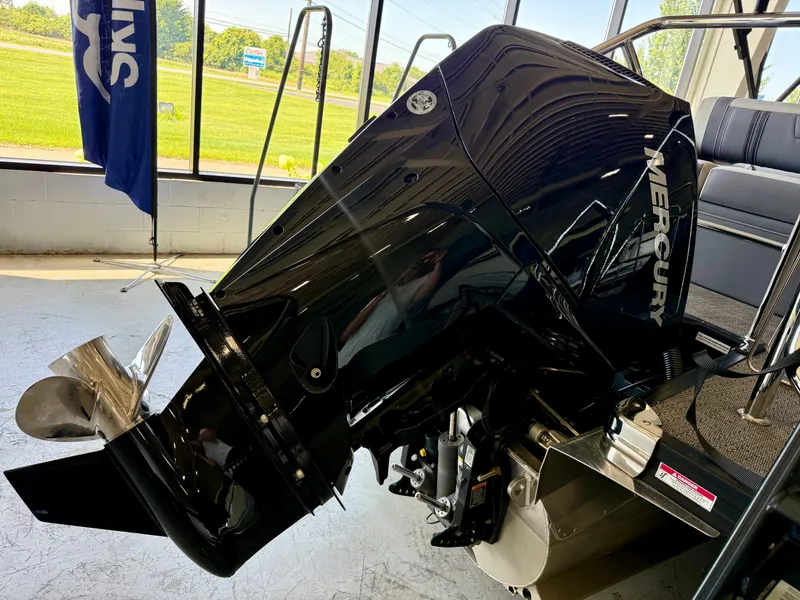 Slide: The Image of A Mercury outboard motor on a Barletta Corsa 23UC boat, indoors with a view of green landscape. - 29