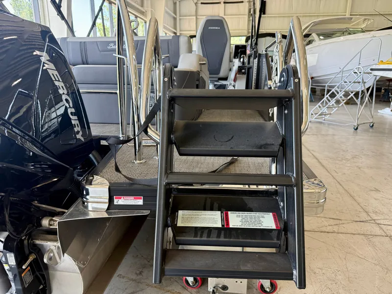 Slide: The Image of The 2025 Barletta Corsa 23UC features a sturdy boarding ladder and a powerful Mercury engine. - 24
