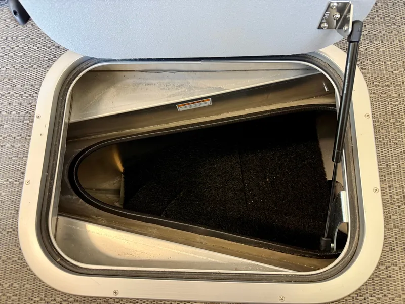 Slide: The Image of An open storage hatch on a boat with carpeted interior. - 21