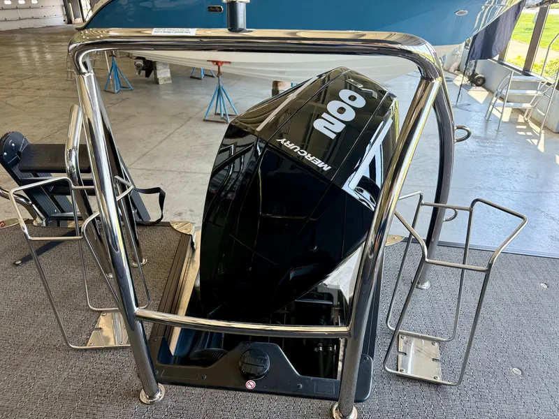 Slide: The Image of A Mercury outboard motor is mounted on a Barletta Corsa 23UC boat, situated indoors. - 28
