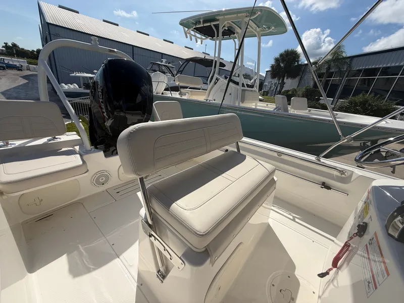 Slide: The Image of The image shows the cockpit of a 2027 Boston Whaler 170 Montauk with beige seats and an outboard motor. - 11