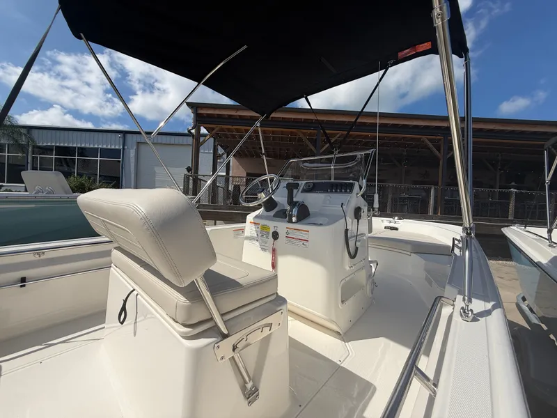Slide: The Image of The image shows the cockpit of a 2027 Boston Whaler 170 Montauk with a white seat and black sunshade. - 14
