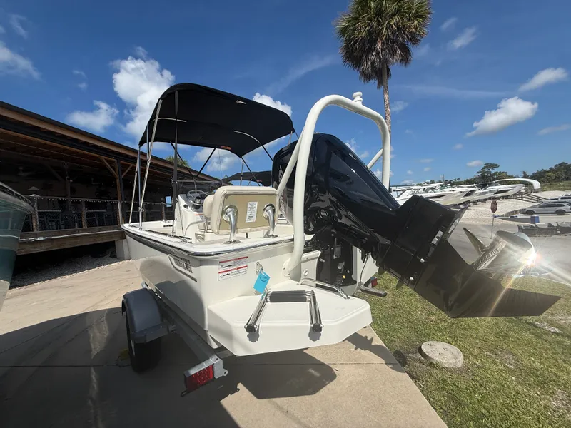 Slide: The Image of A 2027 Boston Whaler 170 Montauk on a trailer. It features a black canopy and an outboard motor. - 4