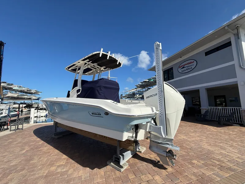 Slide: The Image of A 2027 Boston Whaler 220 Dauntless is on a paved area in front of a building. - 3
