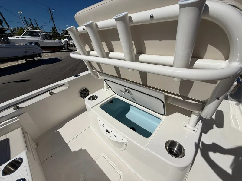 Slide: The Image of The image shows the cockpit of a Boston Whaler 220 Dauntless with rod holders and a blue storage area. - 28