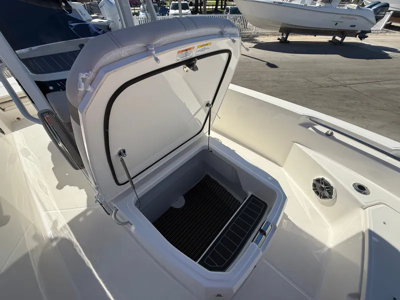 Slide: The Image of An open storage compartment on a Boston Whaler 220 Dauntless boat, surrounded by white upholstery. - 13