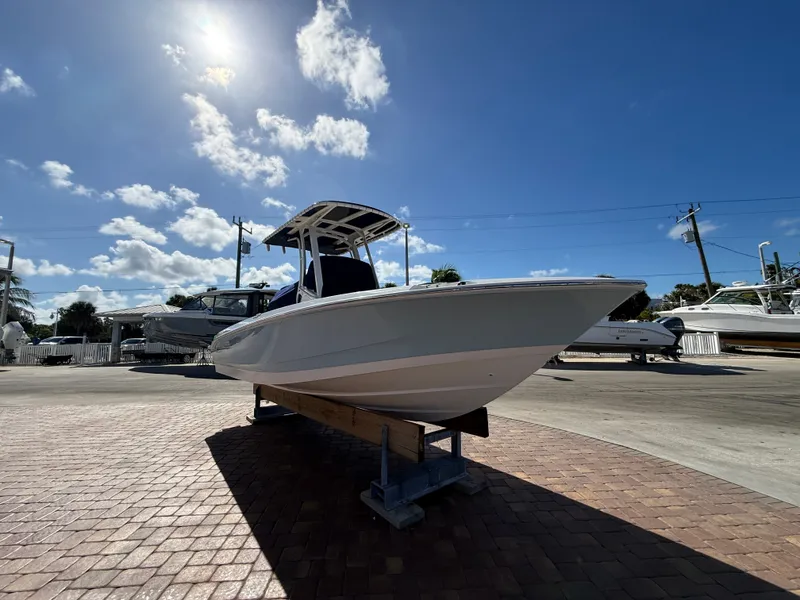 Slide: The Image of A 2027 Boston Whaler 220 Dauntless on a stand under a sunny sky. - 7