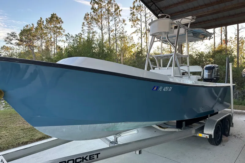 Slide: The Image of 1974 Aquasport 2400 Center Console boat on trailer, parked under a canopy. - 3