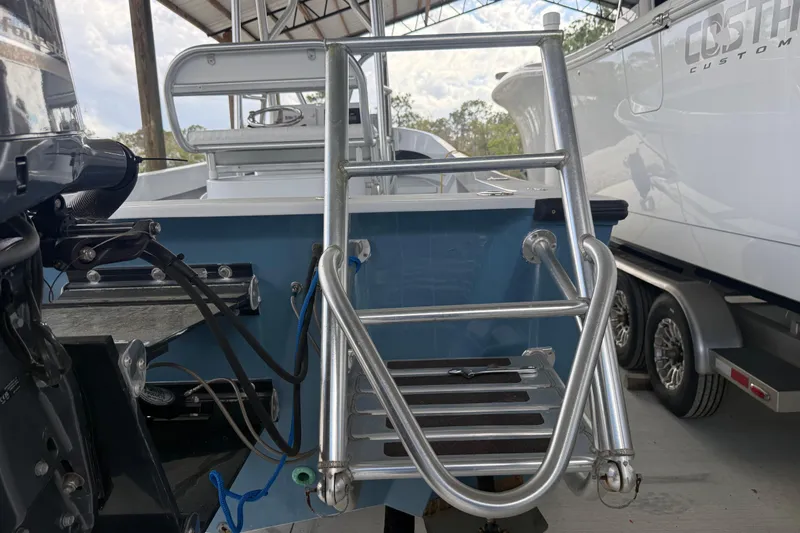 Slide: The Image of 1974 Aquasport 2400 Center Console boat with metal ladder and motor, docked indoors. - 44