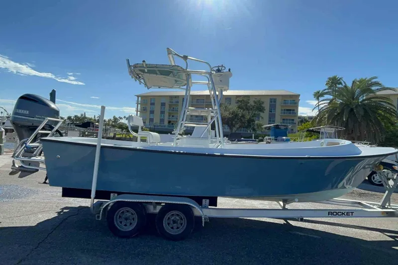 Slide: The Image of A 1974 Aquasport 2400 Center Console boat on a trailer, parked in front of a building. - 48