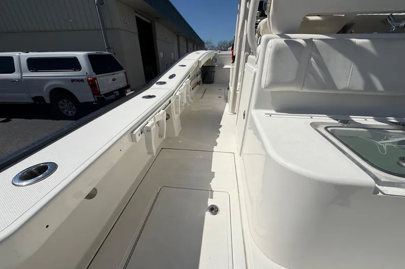 Slide: The Image of 2019 Calcutta 263 boat interior with seating and rod holders, parked near a white truck. - 30