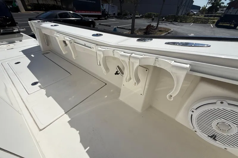 Slide: The Image of 2019 Calcutta 263 boat interior with rod holders and speaker in a parking lot. - 57