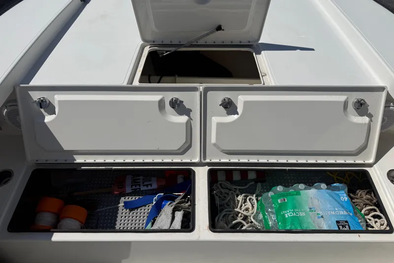 Slide: The Image of Open storage compartments on a 2019 Calcutta 263 boat, containing ropes and supplies. - 62