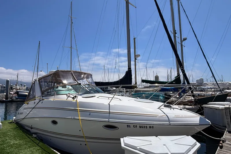 The Image of 2004 Larson 310 boat docked at a marina under a clear blue sky. - 0