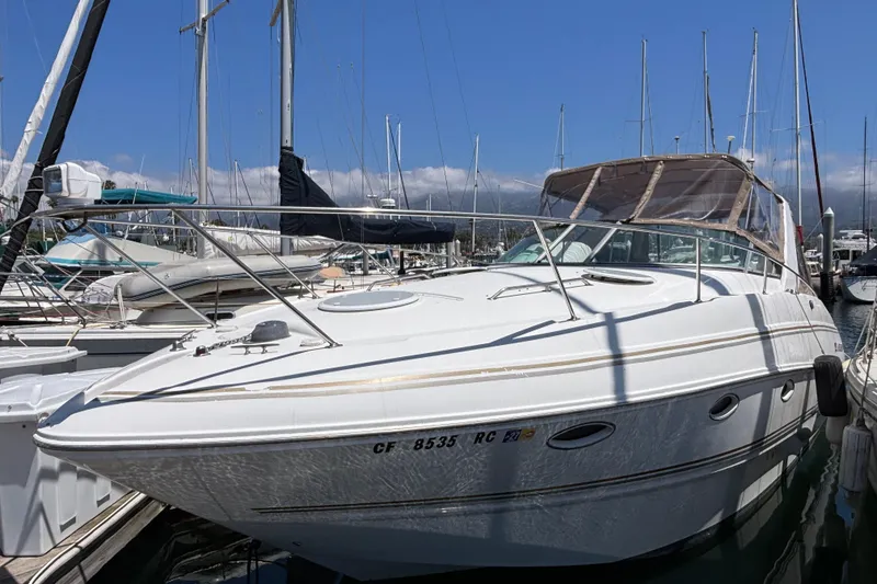 Slide: The Image of 2004 Larson 310 boat docked at marina with clear blue sky background. - 1