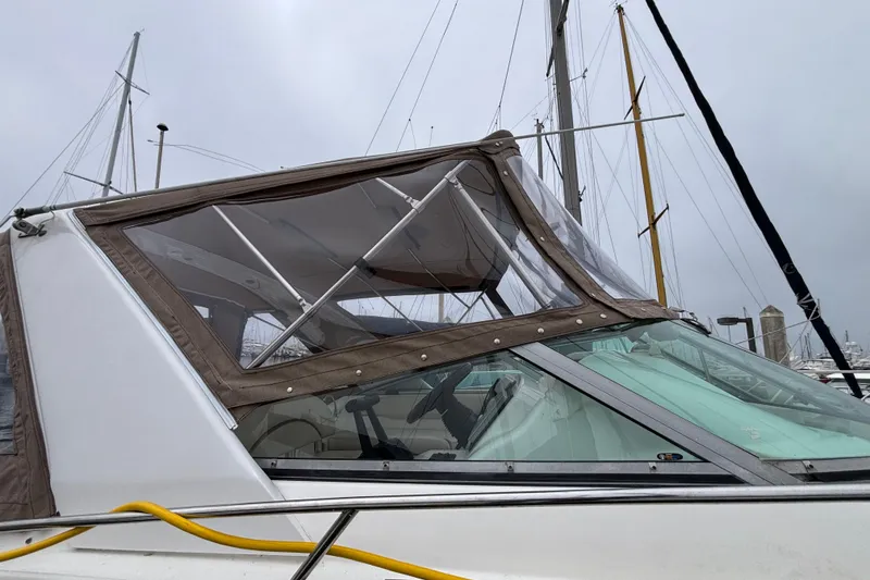 Slide: The Image of 2004 Larson 310 boat with canopy, docked at marina under cloudy sky. - 14