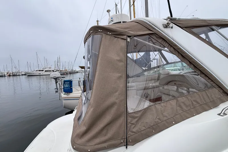 Slide: The Image of 2004 Larson 310 boat docked in a marina with beige canopy. - 15