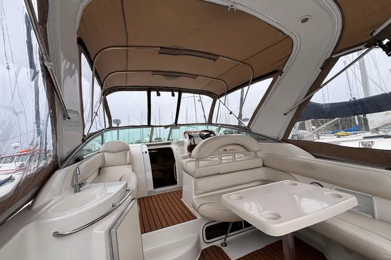Slide: The Image of Interior of a 2004 Larson 310 boat with seating and table under a canopy. - 19