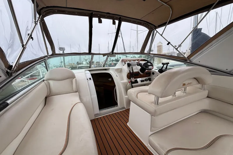 Slide: The Image of Interior of a 2004 Larson 310 boat with beige seating and wooden flooring. - 20