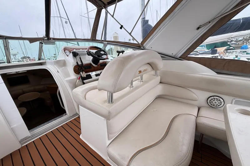 Slide: The Image of 2004 Larson 310 boat interior with white seating and wooden flooring. - 21