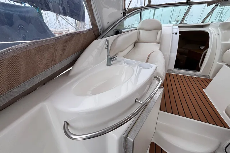 Slide: The Image of Interior of a 2004 Larson 310 boat featuring a sleek sink and comfortable seating. - 24