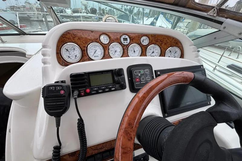 Slide: The Image of Helm of 2004 Larson 310 boat with gauges, radio, and steering wheel. - 25