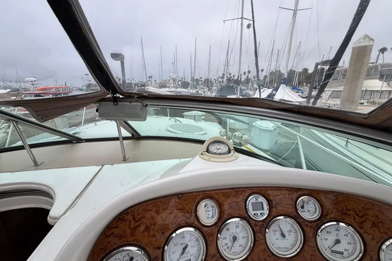 Slide: The Image of Interior view of a 2004 Larson 310 boat dashboard with marina background. - 28