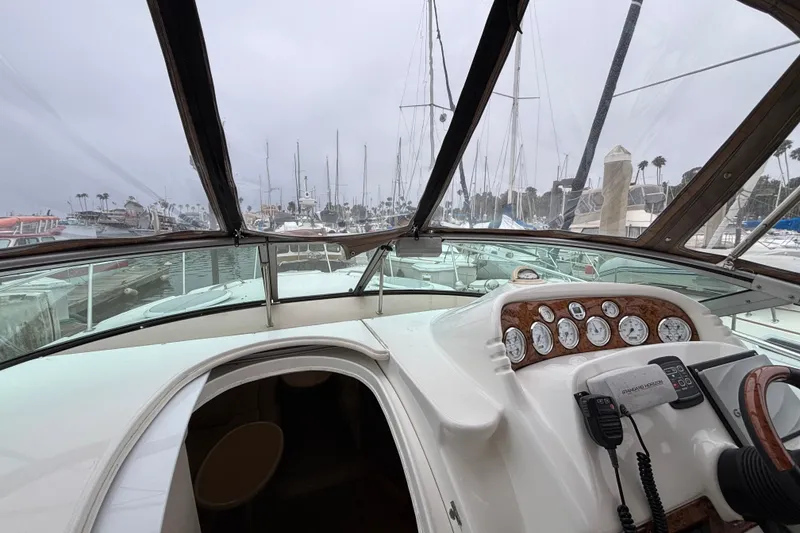 Slide: The Image of Interior view of a 2004 Larson 310 boat cockpit with marina background. - 30