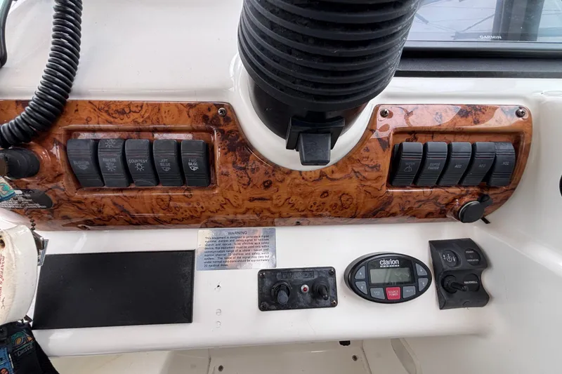 Slide: The Image of Control panel of a 2004 Larson 310 boat with switches and dials. - 31