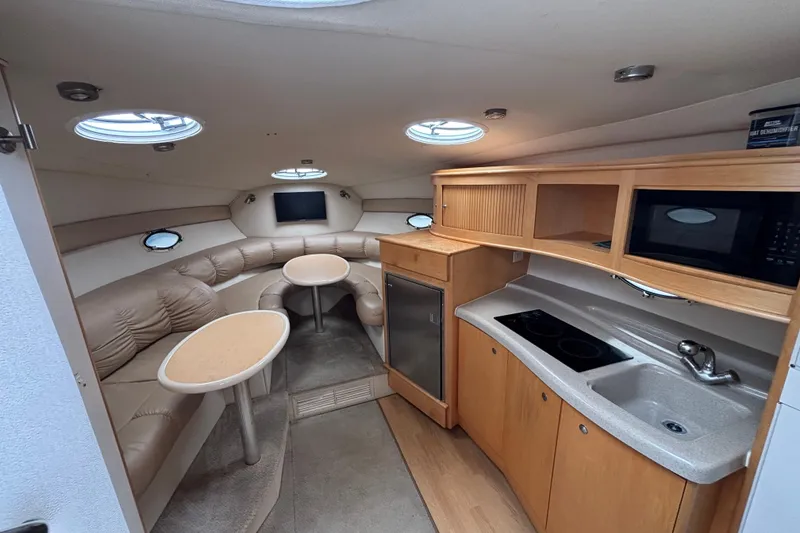 Slide: The Image of Interior of a 2004 Larson 310 boat with kitchenette and seating area. - 35
