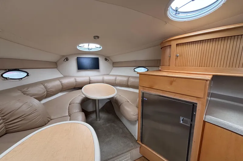 Slide: The Image of Interior of a 2004 Larson 310 boat with cozy seating and modern amenities. - 36
