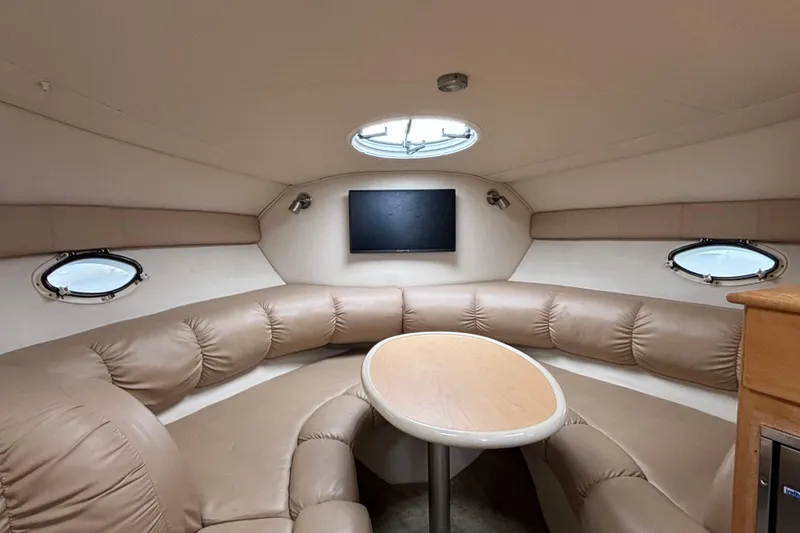 Slide: The Image of Interior of a 2004 Larson 310 boat with beige seating and a round table. - 37