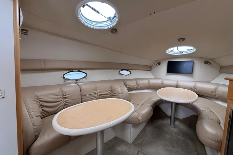 Slide: The Image of Luxurious interior of 2004 Larson 310 boat with leather seating and round tables. - 38