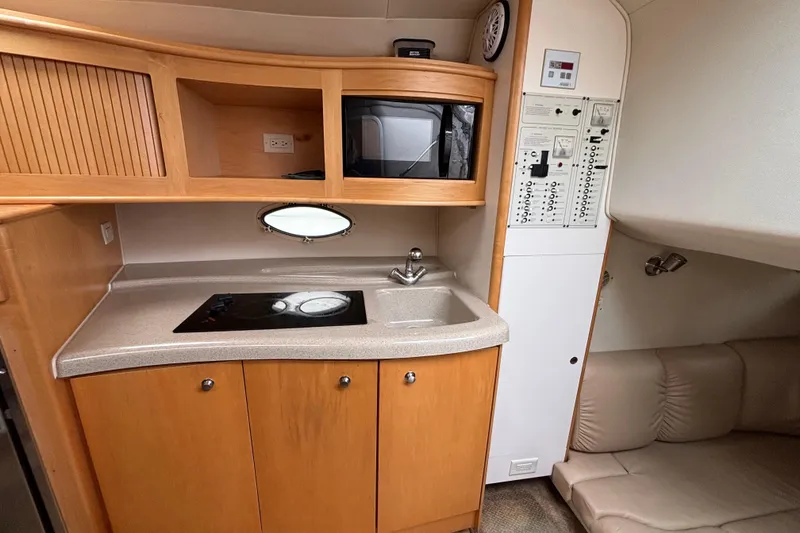 Slide: The Image of 2004 Larson 310 boat interior with kitchenette, microwave, and control panel. - 40