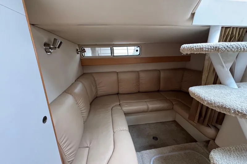 Slide: The Image of Interior of a 2004 Larson 310 boat with beige leather seating and carpeted stairs. - 43