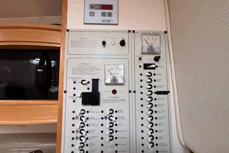Slide: The Image of Electrical control panel in a 2004 Larson 310 boat, featuring AC and DC service switches. - 47