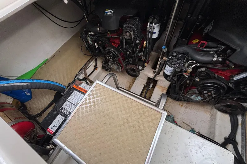 Slide: The Image of Engine compartment of a 2004 Larson 310 boat, showing dual engines and battery. - 50