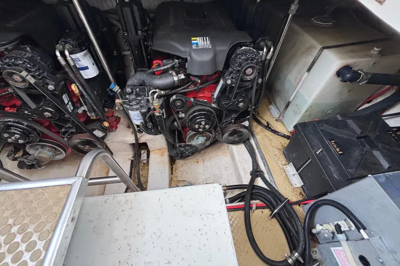 Slide: The Image of Engine compartment of a 2004 Larson 310 boat, showing dual engines and mechanical components. - 51