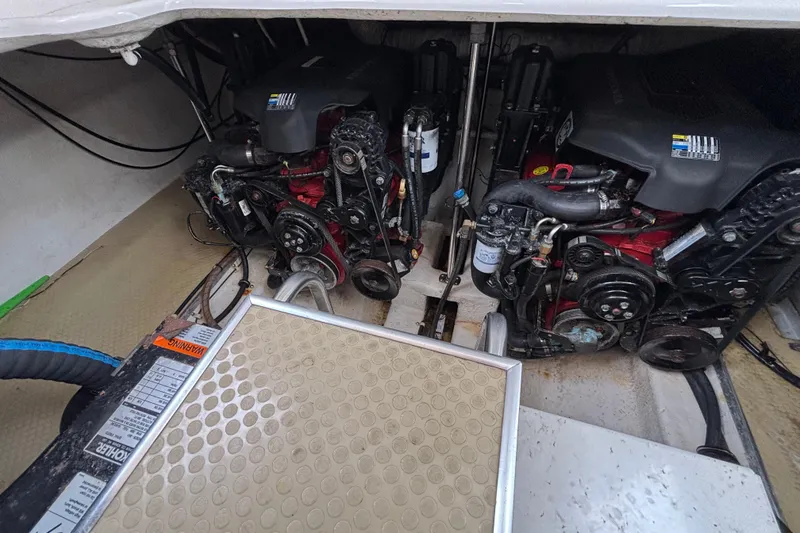 Slide: The Image of Engine compartment of a 2004 Larson 310 boat, showcasing dual engines and mechanical components. - 55