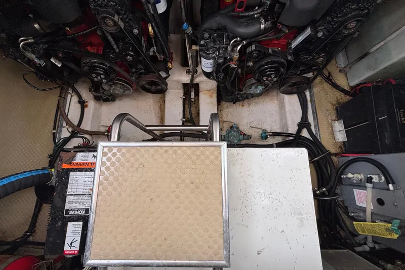 Slide: The Image of Engine compartment of a 2004 Larson 310 boat, showcasing dual engines and mechanical components. - 56