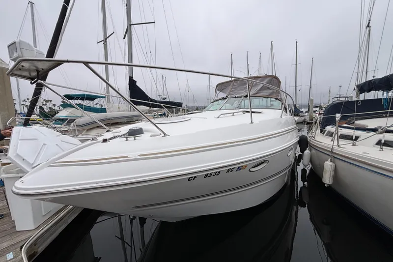 Slide: The Image of 2004 Larson 310 boat docked at marina, surrounded by other sailboats. - 8