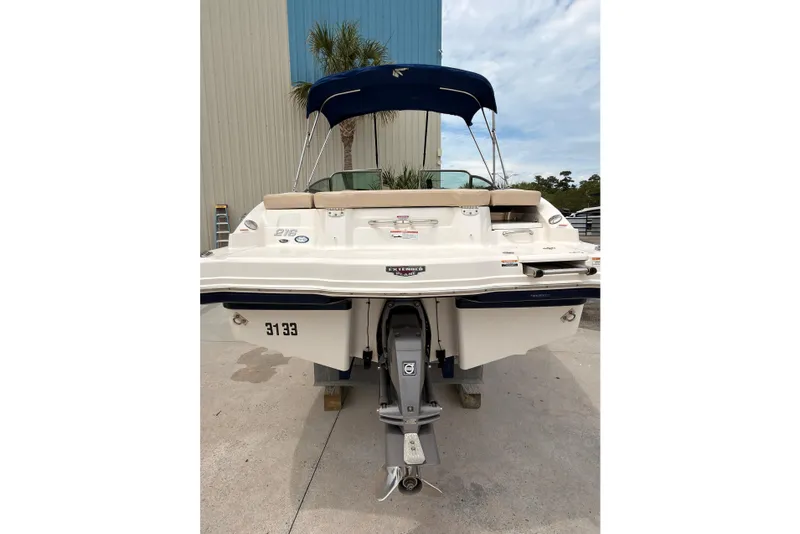 Slide: The Image of 2012 Chaparral 216 SSi boat with blue canopy, docked outdoors. - 8