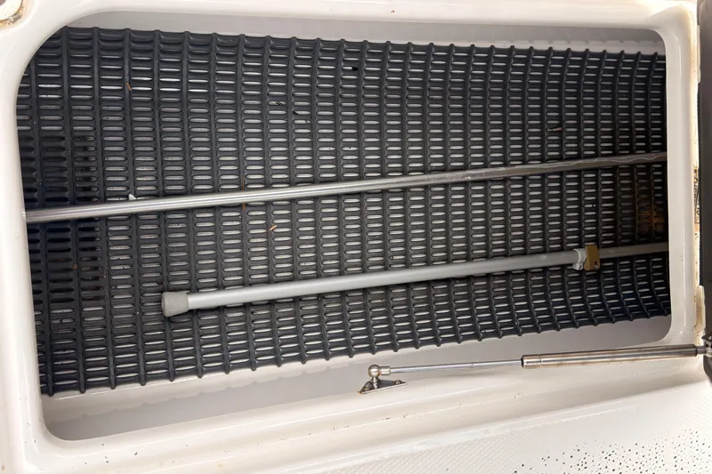 Slide: The Image of Storage compartment of a 2012 Chaparral 216 SSi boat with metal rods and textured flooring. - 36
