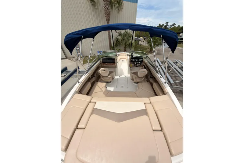 Slide: The Image of 2012 Chaparral 216 SSi boat interior with beige seating and blue canopy. - 9