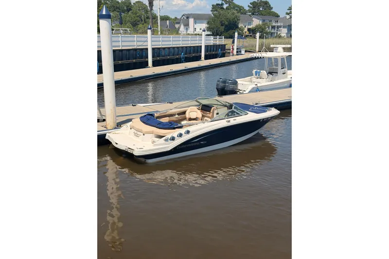 Slide: The Image of 2012 Chaparral 216 SSi boat docked at a marina, featuring sleek design and spacious seating. - 1