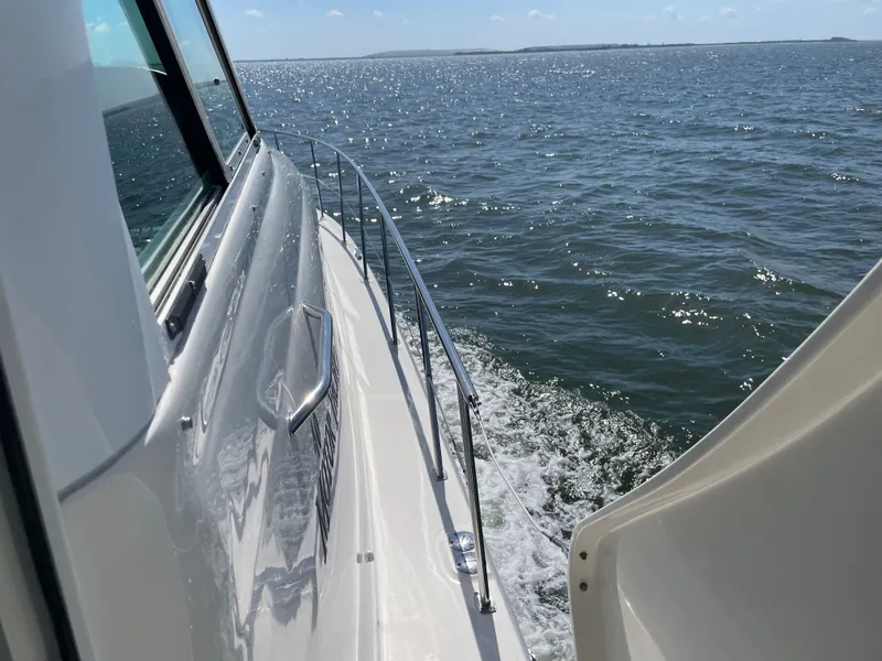 Slide: The Image of A white boat cruising on calm water under a blue sky. - 14