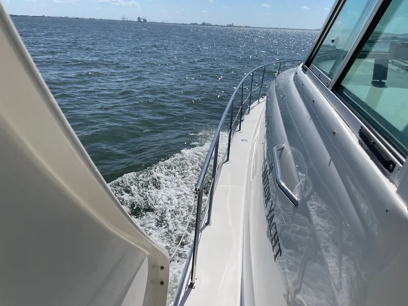 Slide: The Image of A boat cruising on calm water with a view of the distant shoreline. - 15