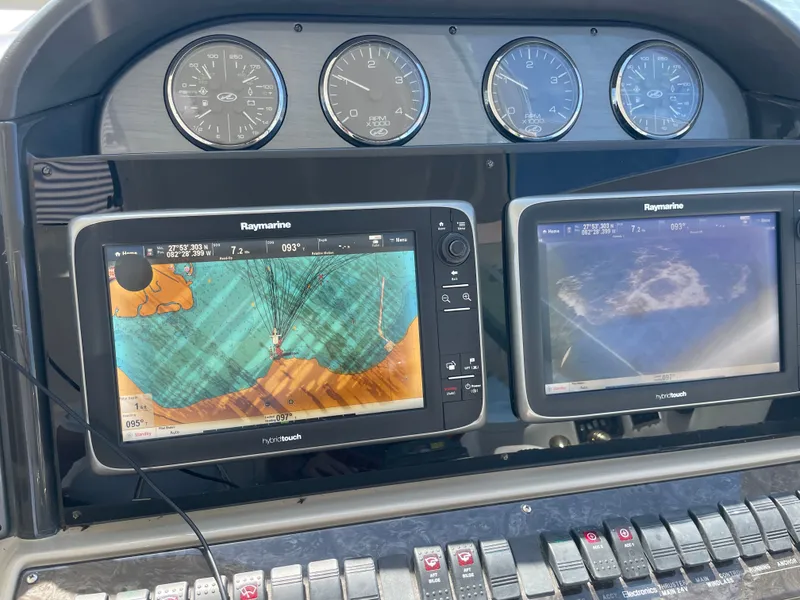 Slide: The Image of The dashboard of a boat with two Raymarine screens and several gauges. - 20
