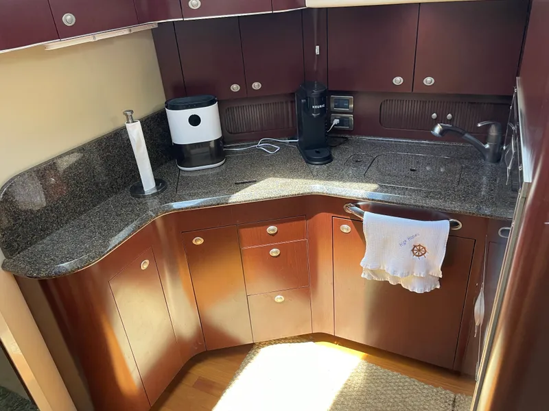 Slide: The Image of A sleek boat kitchen with dark wood cabinets and granite countertop. - 26
